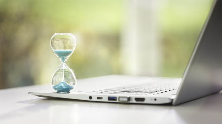 Laptop mit Sanduhr als Symbol der Arbeitszeit